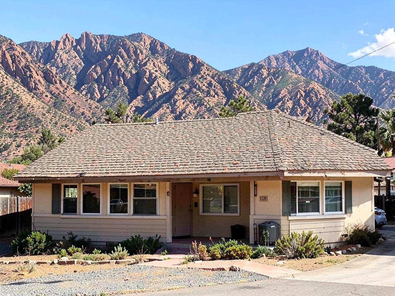 Aging composition shingle roof on an El Cajon, CA home with dry mountains behind it